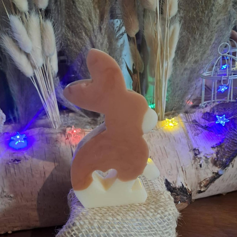Bougie artisanale représentant un petit lapin bicolore avec un cœur sculpté, disponible en format pot de 265g ou palet de 80g, décoration de chambre et cadeau de naissance.