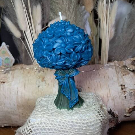 Bougie artisanale sculptée en forme de bouquet de marguerites avec tiges vertes, fleurs bleues personnalisables, décoration style champêtre et bohème.