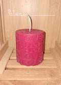 Bougie artisanale cylindrique avec le mot LOVE gravé en relief sur toute la surface, créant un motif graphique moderne, poids 108g, cire naturelle.