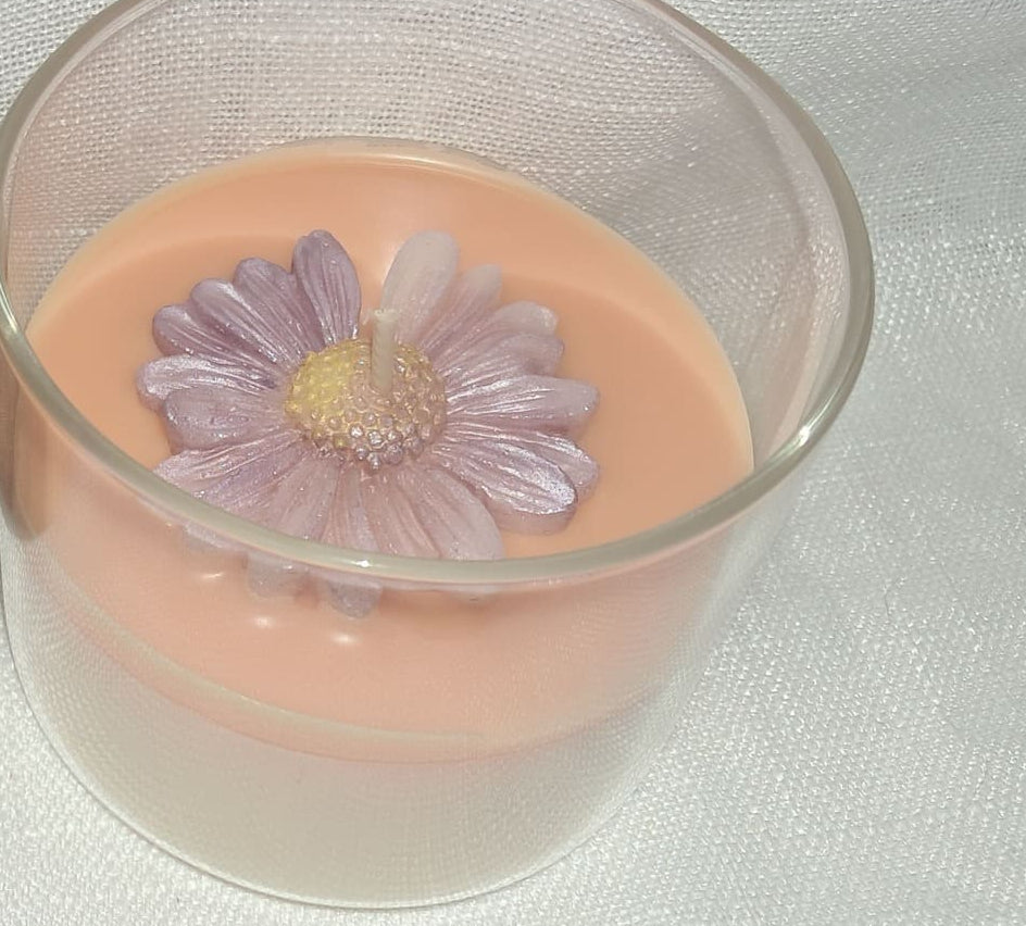 Bougie artisanale dans un contenant en verre ouvert, décorée d'une marguerite en cire à la surface, style bucolique et romantique, poids 265g.