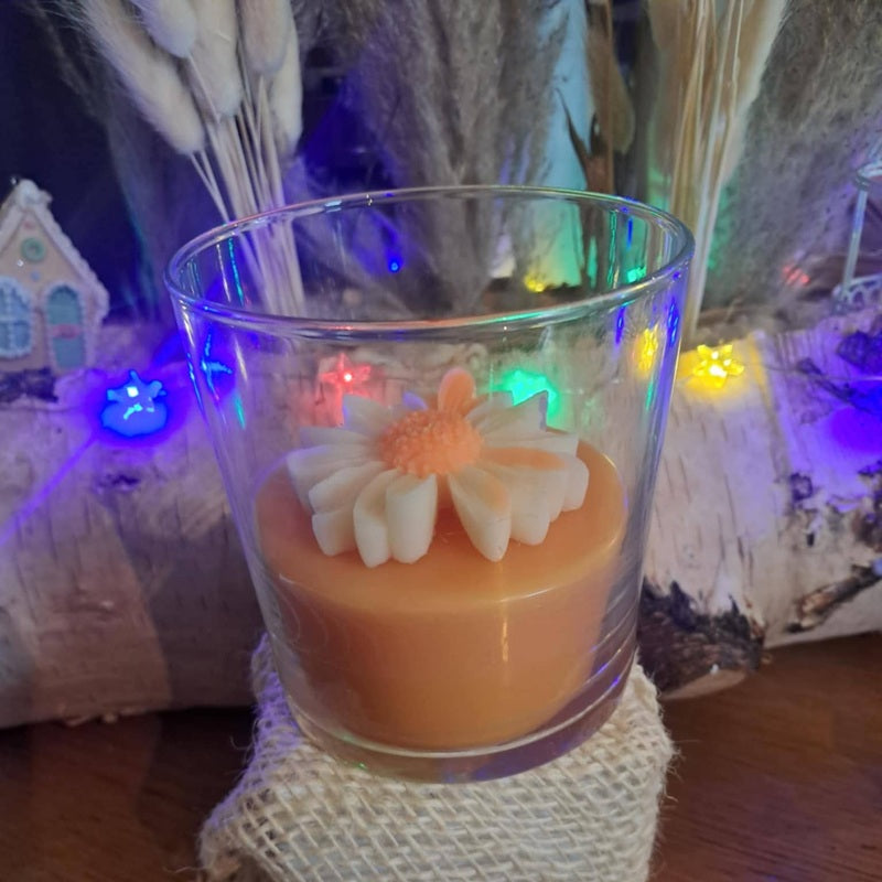 Bougie artisanale dans un contenant en verre, décorée d'une marguerite blanche en cire à la surface, style champêtre et romantique, poids 265g.