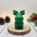 Bougie artisanale en forme de petit bébé renne vert, faite main. Une décoration de Noël mignonne et poétique pour une ambiance forêt enchantée et cocooning.