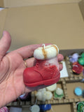 Bougie artisanale en forme de botte de noël rouge avec détails de fourrure en cire, faite main pour une décoration de Noël chaleureuse et conviviale.