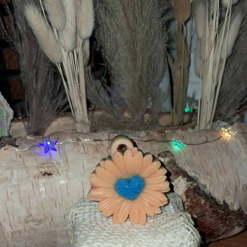 Bougie artisanale en forme de grande marguerite, pétales blancs texturés et cœur central bleu, poids 135g, style décoratif printanier.