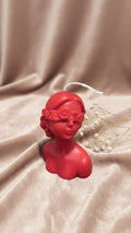 Bougie rouge artisanale en forme de buste de femme aux courbes délicates, style sculpture antique et minimaliste pour décoration d'intérieur.