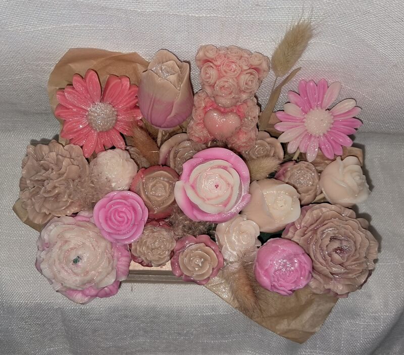 Grand bouquet de fondants parfumés artisanaux vu de dessus avec un ourson en cire et des fleurs sculptées, présentés dans un pot en bois naturel réutilisable.
