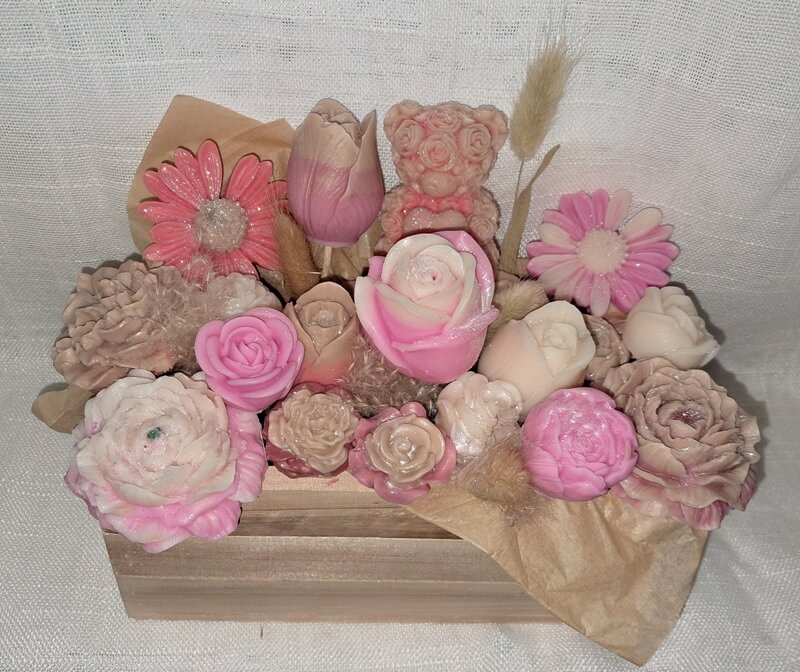 Grand bouquet de fondants parfumés artisanaux avec un ourson en cire et des fleurs sculptées, présentés dans un pot en bois naturel réutilisable.
