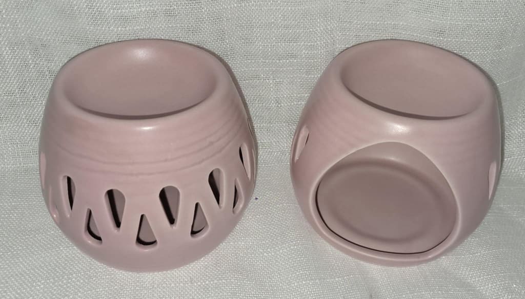 Ensemble de décoration composé d'un brûleur en céramique rose et de trois grands fondants de cire en forme de fleurs et de cœur, pour un moment de détente cocooning.