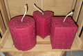 Ensemble de trois bougies artisanales sculptées avec le mot LOVE : une forme cœur, une forme carrée et une forme cylindrique, présentées ensemble comme centre de table.