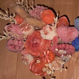 Composition florale artisanale dans un pot en plâtre résine travaillé printanier, contenant un ourson de roses et des fleurs en cire parfumée, utilisables comme fondants de cire.