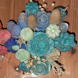 Composition florale artisanale dans un pot en plâtre résine travaillé, contenant un ourson de roses et des fleurs en cire parfumée, utilisables comme fondants de cire.