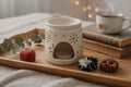 Kit complet de parfum d'ambiance comprenant un brûleur en céramique blanche et trois grands fondants de cire sculptés à la main : frangipanier, marguerite et cœur floral.
